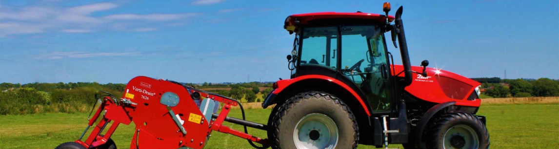 Landscape of red tractor against a field backdrop.