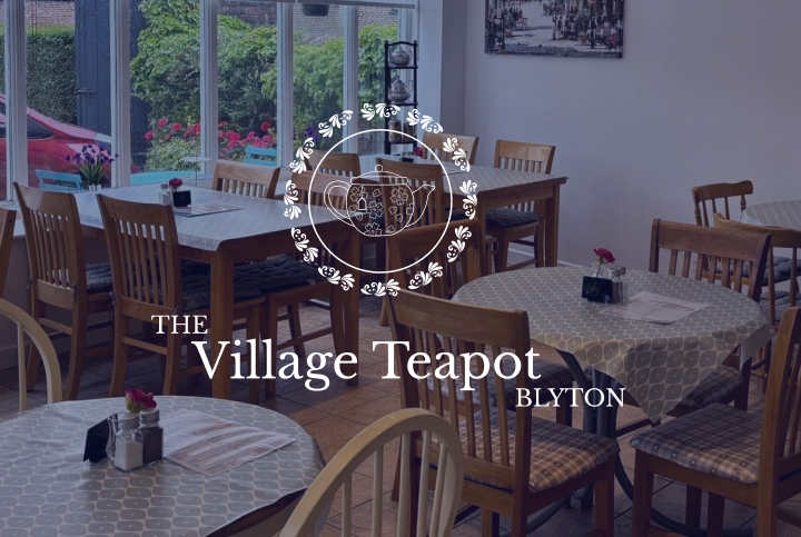 A room of table and chairs in a cafe building with The Village Teapot logo overlayed.